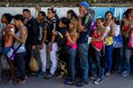 People queue to buy basic food and household items outside a supermarket in Caracas, on Sept. 28, 2016.
