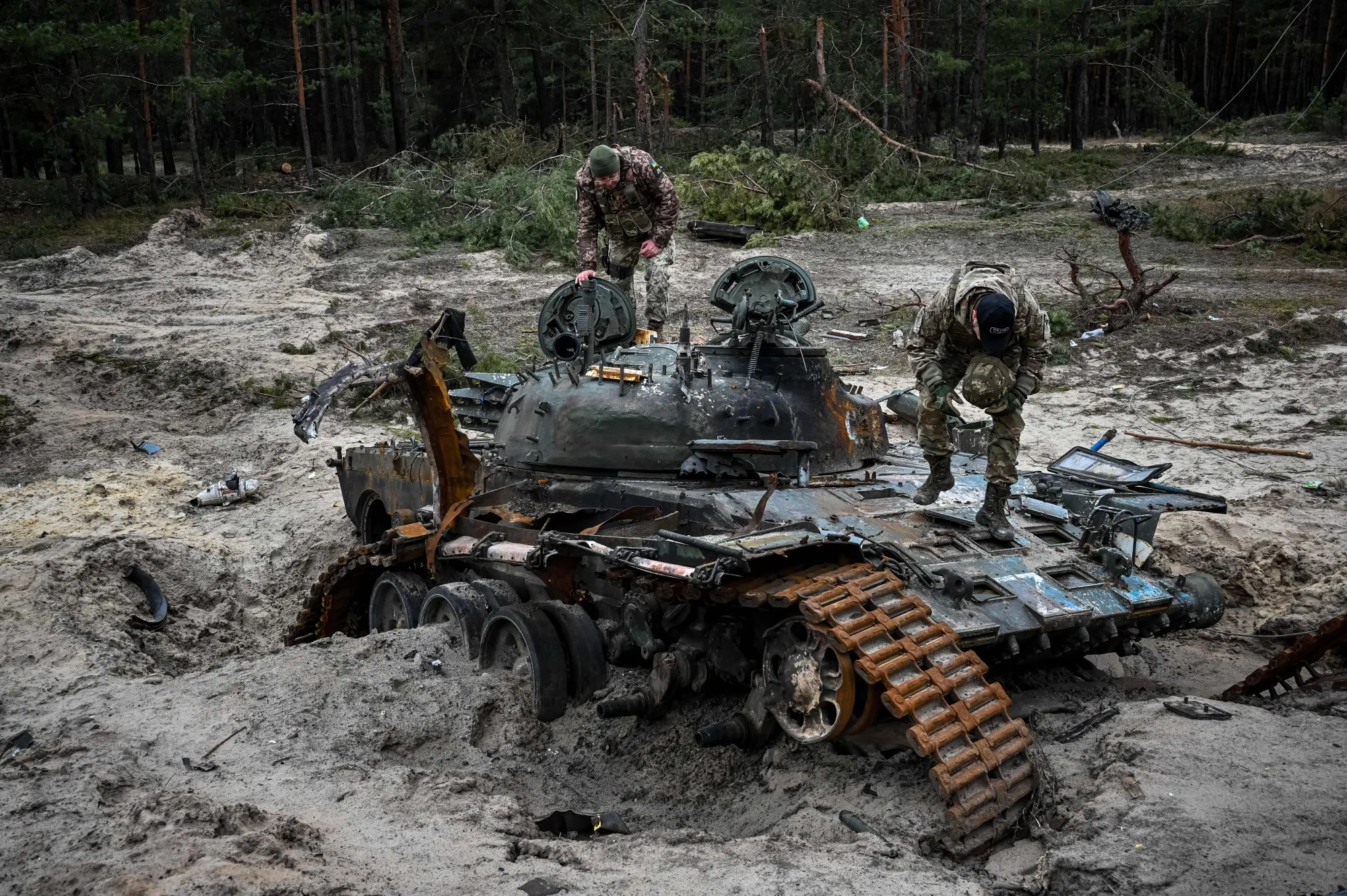 Ukrainian servicemen inspect a destroyed Russian tank in Kharkiv region on Dec. 15.