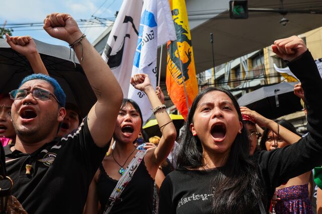Демонстранты болтают лозунги и поднимают кулаки в воздух во время акции протеста против коррупции в Манниле.
