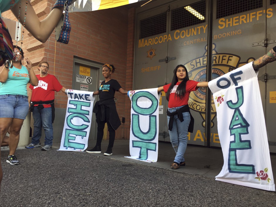 A group of protesters chain themselves to each other outside the Maricopa County Jail in downtown Phoenix during a protest against the sheriff's relationship with Immigration and Customs Enforcement.