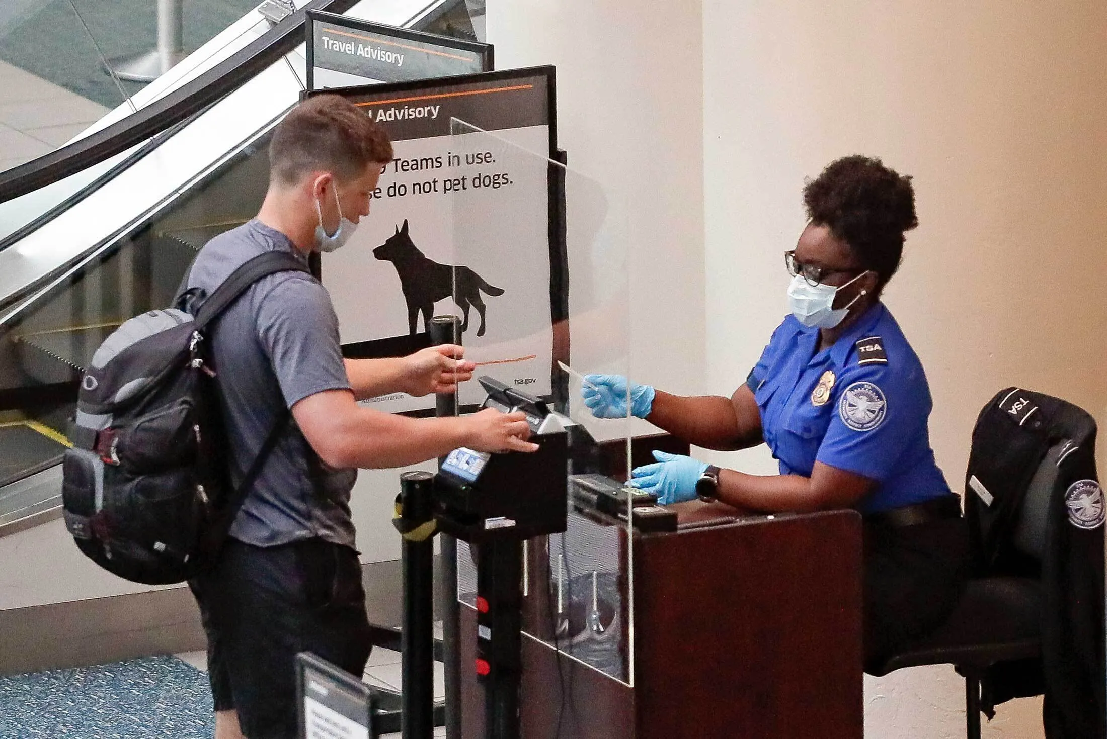 A TSA worker checks a passenger at Orlando International Airport&nbsp;on June 17.