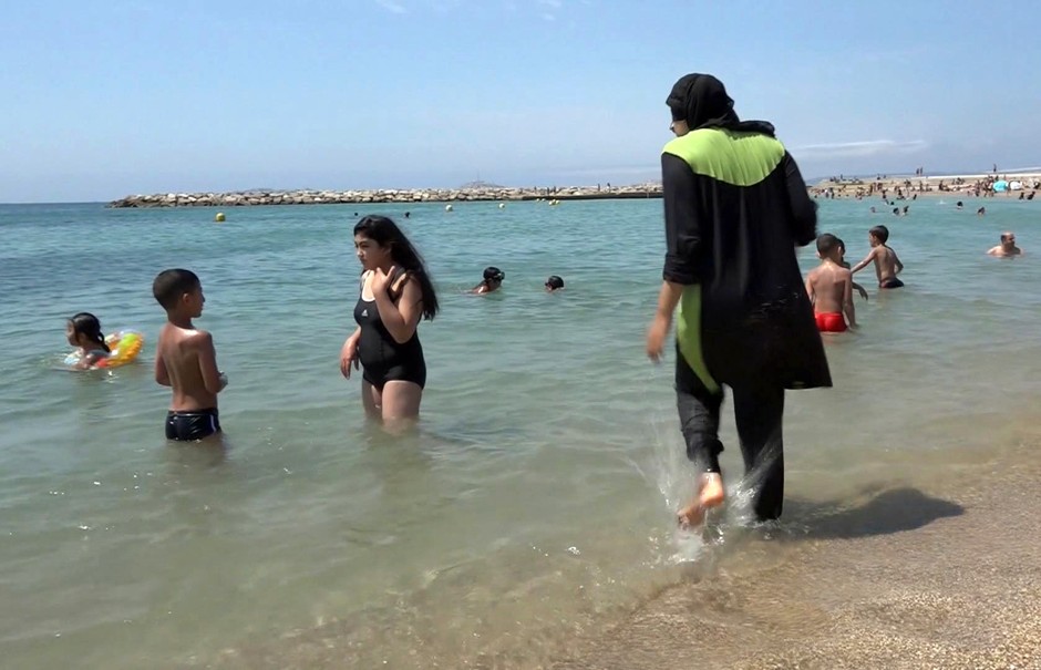 A burkini-clad woman prepares to swim in Marseille, France.