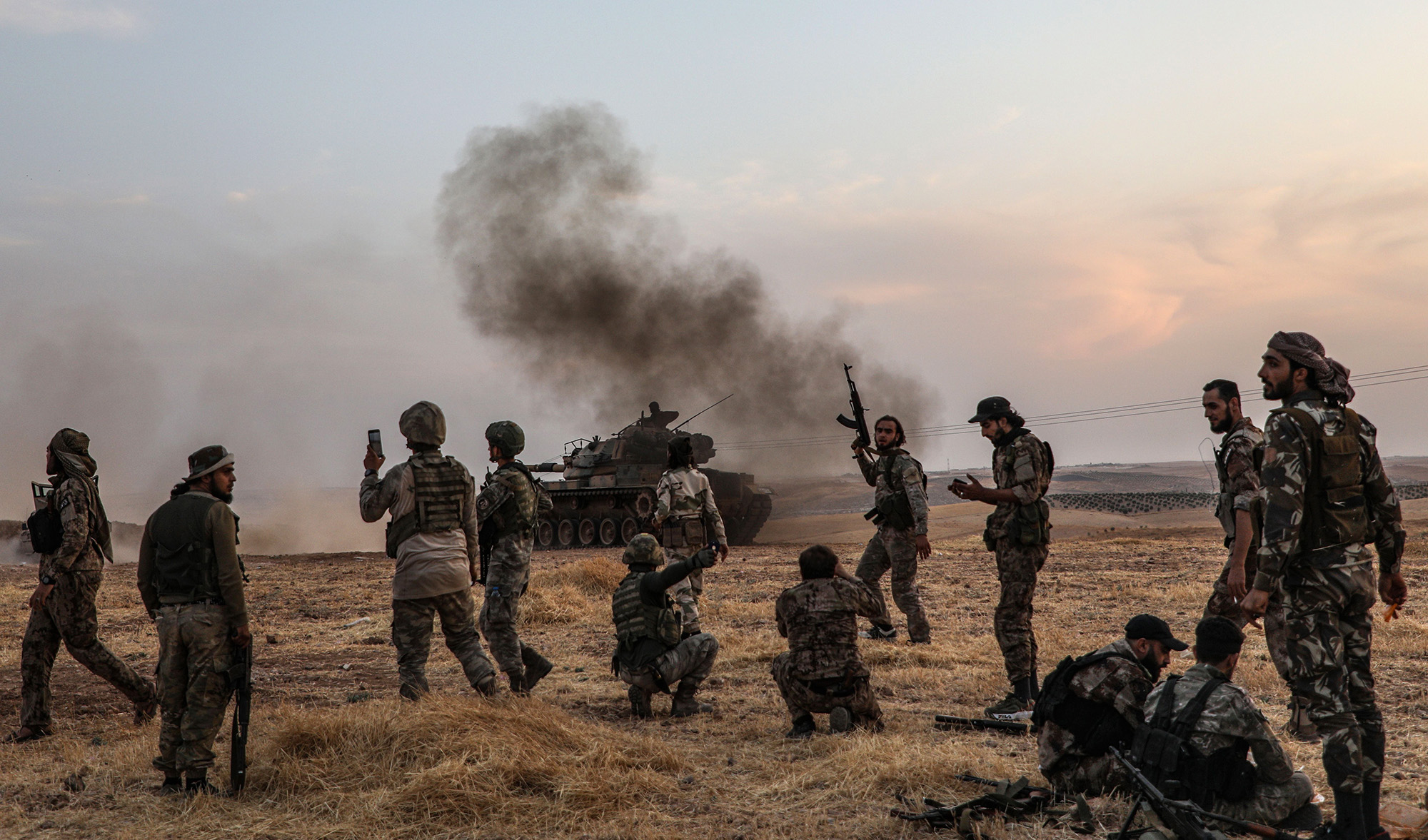 Turkish soldiers and Turkey-backed Syrian fighters gather on the northern outskirts of Manbij, Syria near the Turkish border on Oct. 14.
