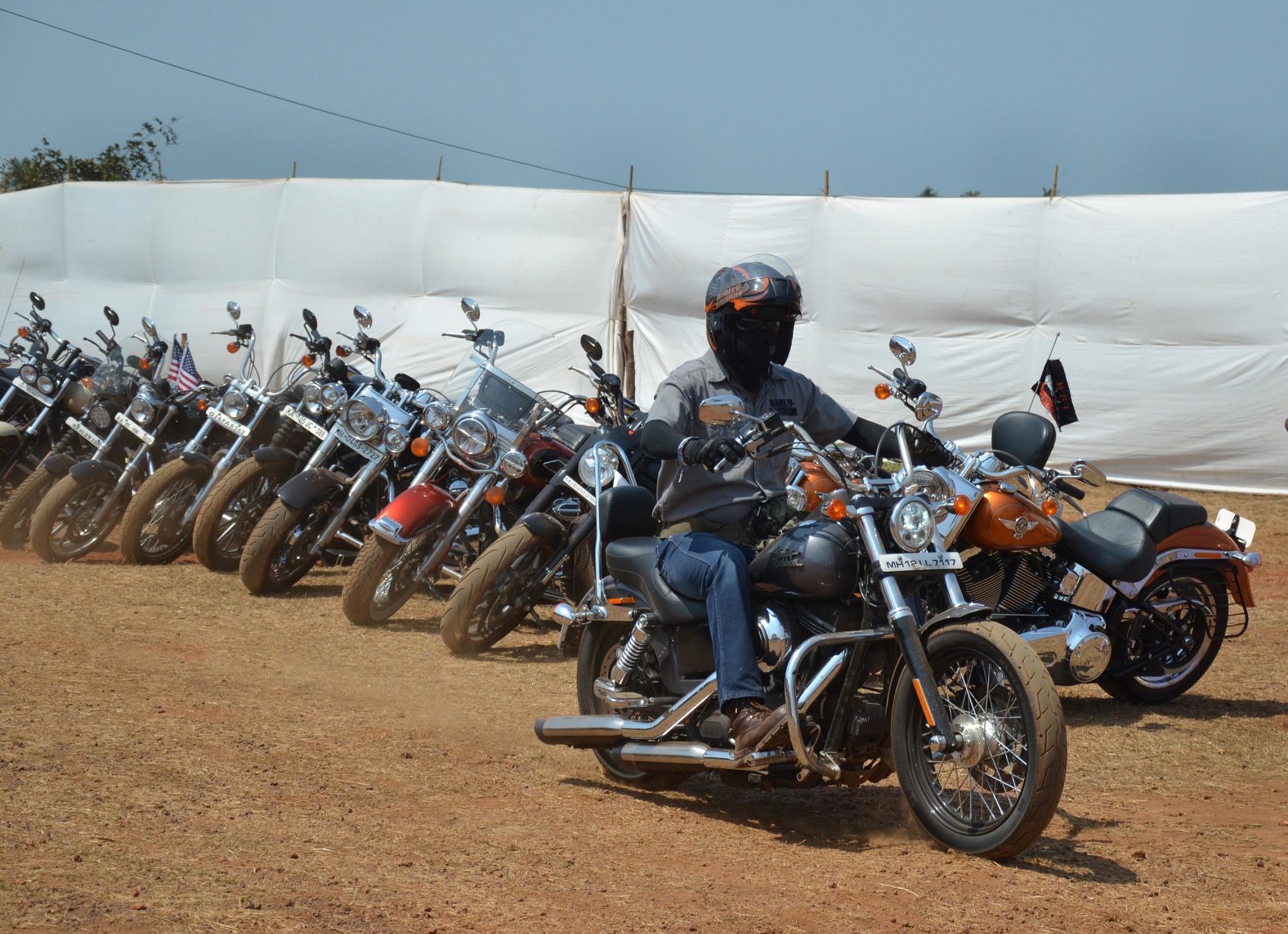A motorcyclist drives a Harley-Davidson motor-cycle past a row of Harleys on display in Goa.