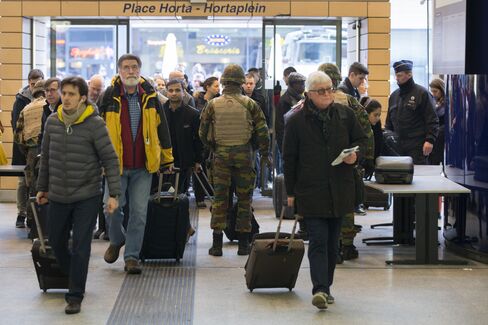 Armed soldiers stand guard as travelers enter Brussels Midi railway station on March 23.