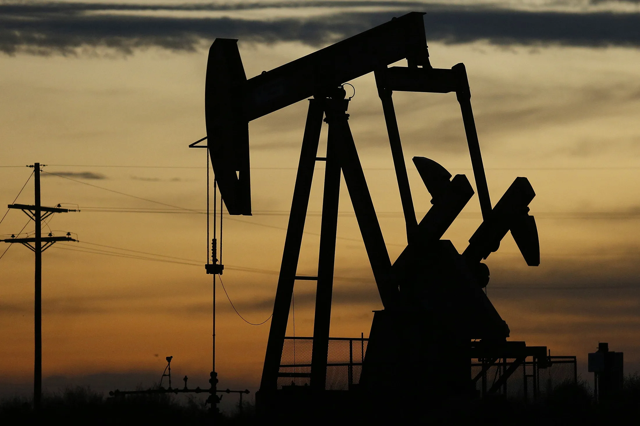 The silhouette of an electric oil pump jack is seen at dusk in the oil fields surrounding Midland, Texas, U.S., on&nbsp;Nov. 7, 2017.