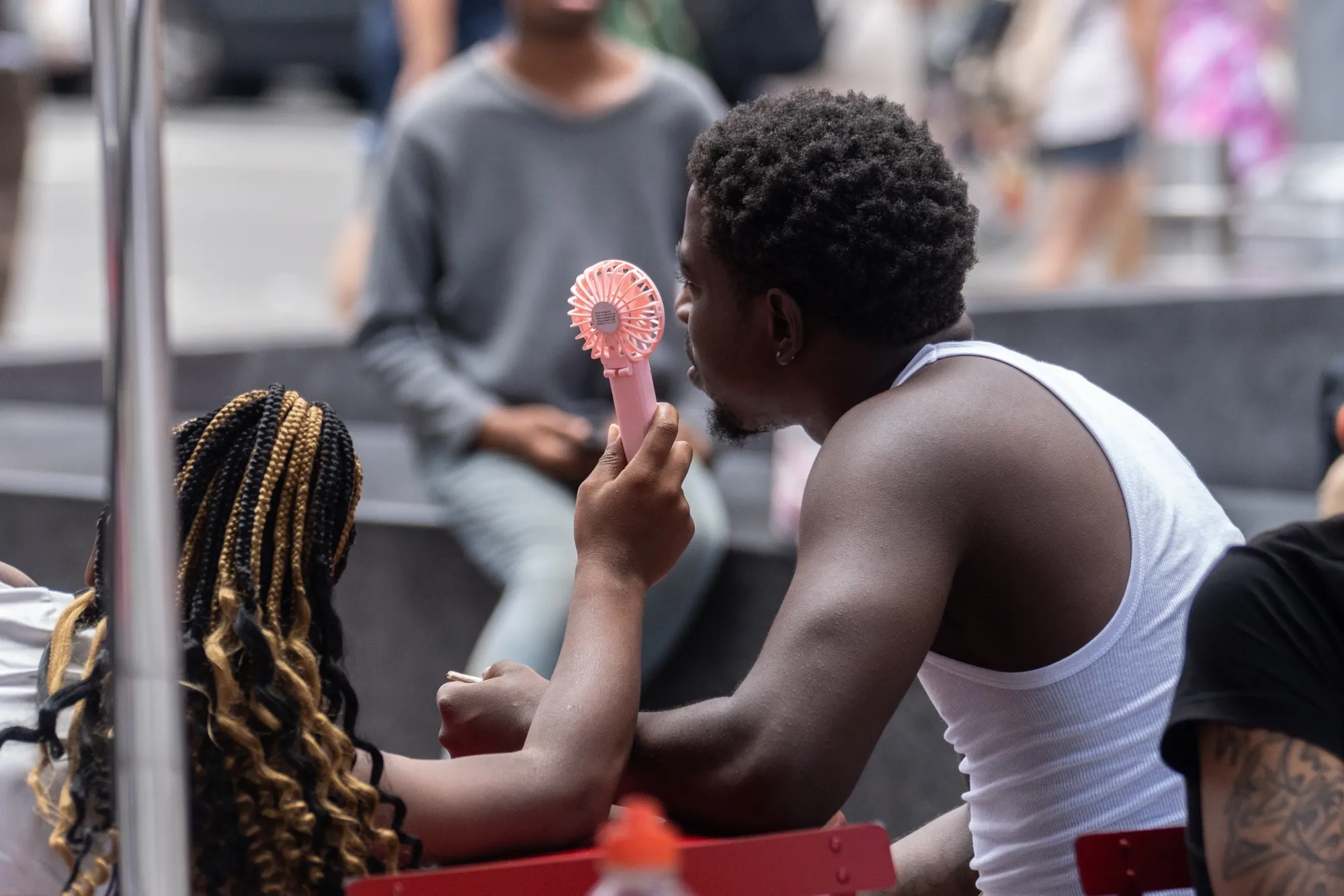 Residents use a handheld fan during a heat wave in New York in 2023.