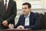 Alexis Tsipras, Greek Prime Minister-elect, signs a book as he is sworn in as prime minister at a ceremony at the presidential palace in Athens, Greece, Jan. 26, 2015.

