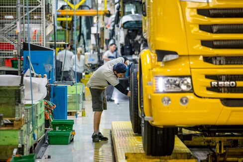 An employee works on the assembly of a Scania R520 truck as it passes along the production line inside the Scania AB plant in Sodertalje, Sweden, on March 26, 2014.