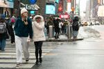 Two women cross 42nd Street in Times Square after an overnight snowstorm on Dec. 27 in New York.