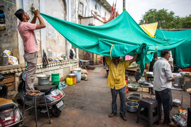 Roadside vendor's is seen setting up shade to escape from suns heat in Ahemdabad, Gujarat, India, on Friday, May 6, 2023. Photographer: Prashanth Vishwanathan/Bloomberg