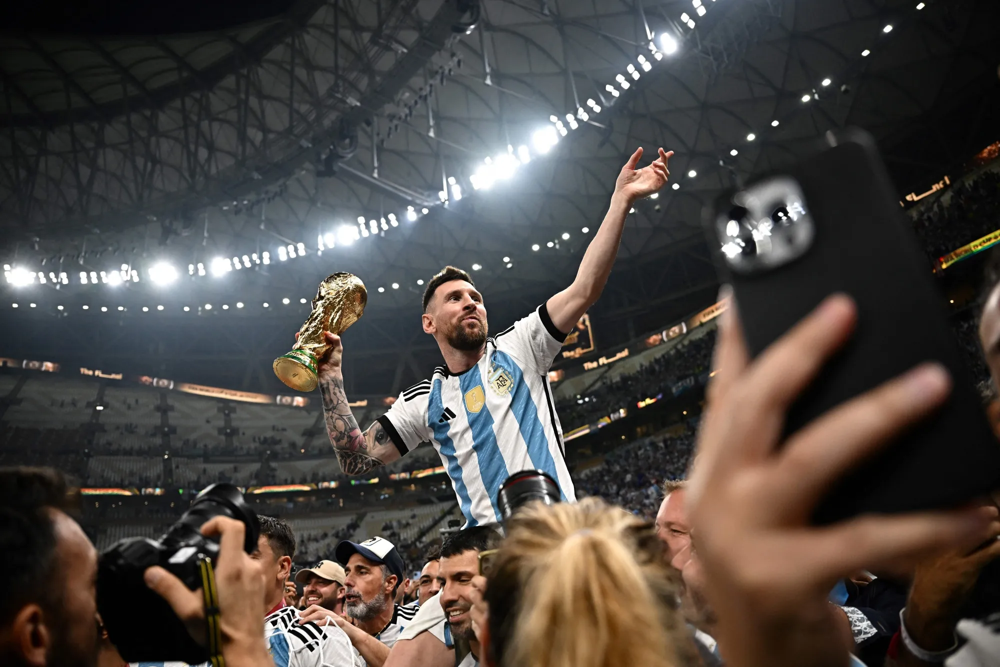 Lionel Messi with the FIFA World Cup trophy in Lusail, Qatar. Photographer Anne-Christine Poujoulat/AFP/Getty Images