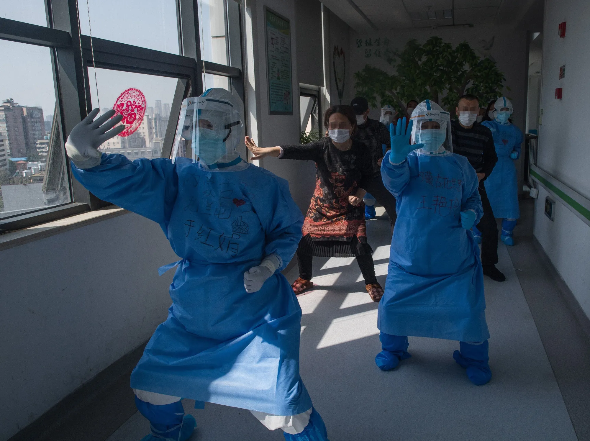 Medical workers lead patients during an aerobics exercise at the Wuhan pulmonary hospital on March 19.