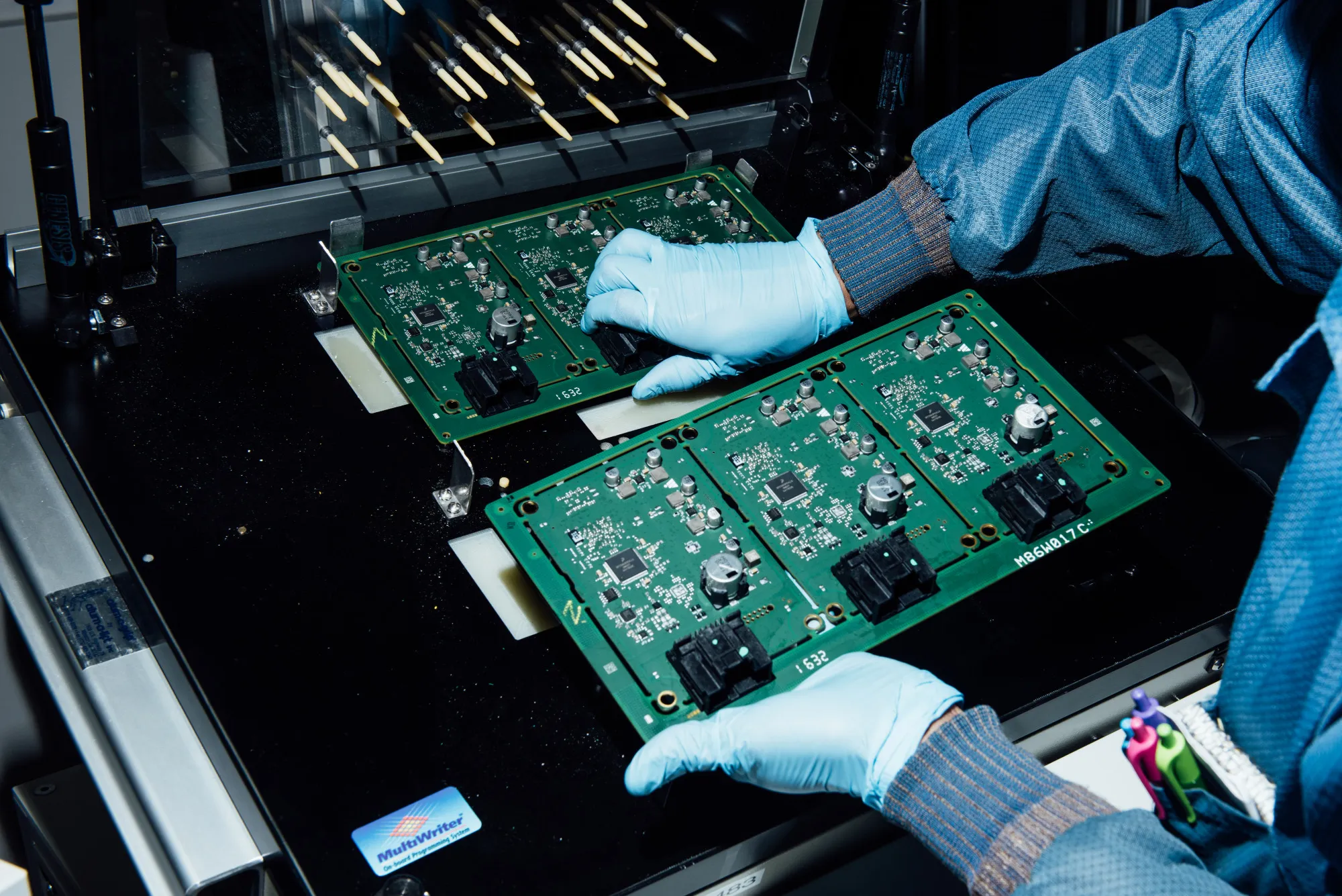A technician handles electronic components at the Magna International Inc. office in Holly, Michigan.