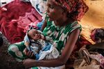 An Ethiopian refugee with her new born daughter in a makeshift tent at the Border Reception Centre.&nbsp;