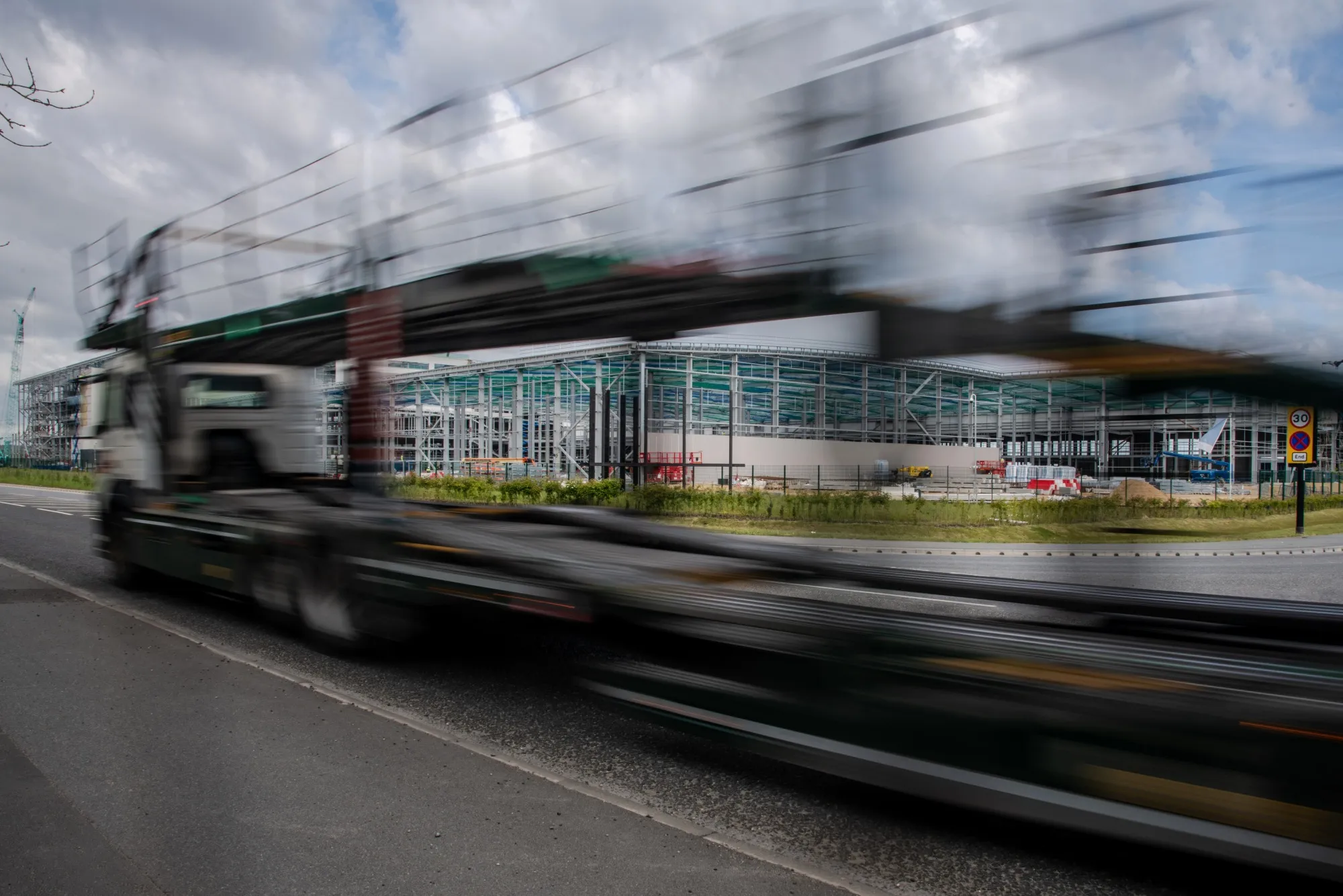 An empty car carrier trailer passes the construction site of the new Nissan gigafactory in Sunderland.