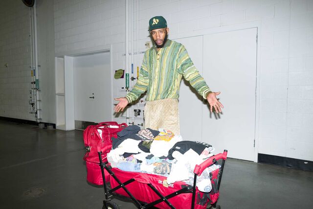 J.R. Bradley stands next to a wagon and suitcase full of clothing