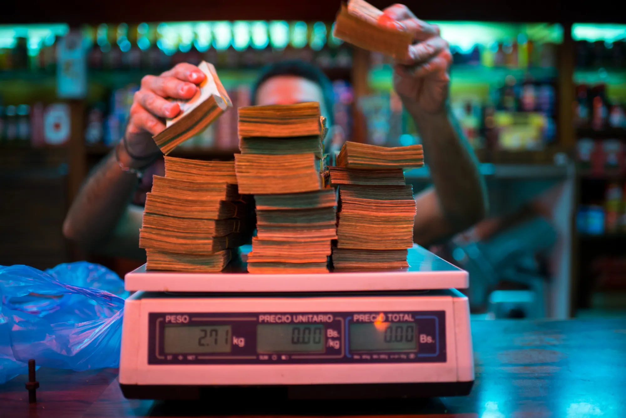 A manager weighs banknotes on a scale at a Caracas bakery on Oct. 13, 2016.