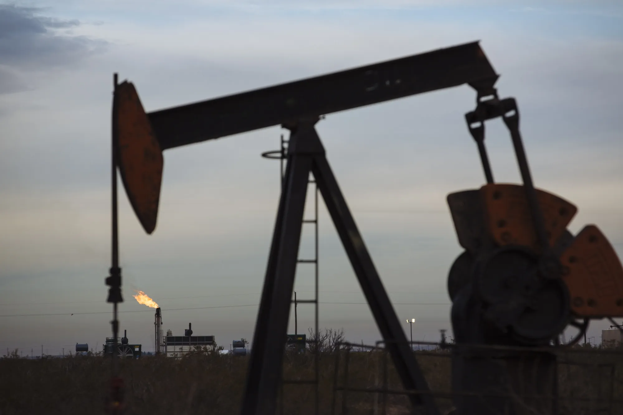 A gas flare burns past a pump jack in Texas.