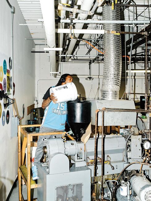 2. An employee adds vinyl pellets to a record press.