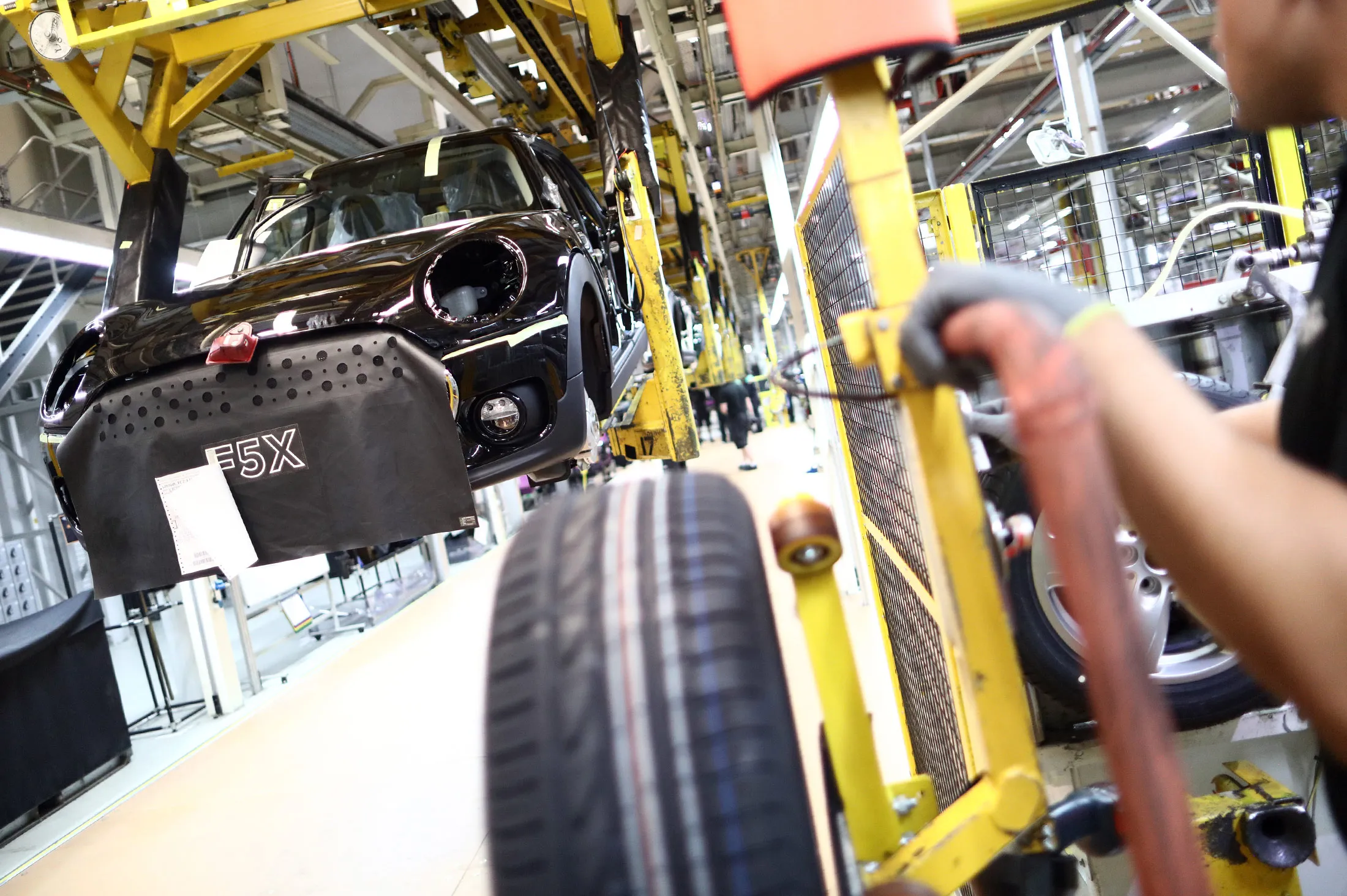 An employee prepares to fit a wheel to a Mini automobile, produced by Bayerische Motoren Werke AG (BMW), inside the final assembly plant in Oxford, U.K., on Tuesday, Sept. 20, 2016. The U.K. should maintain European Union regulations covering everything from working hours to chemicals until after the government sets out its plans for Brexit, said British manufacturers anxious to avoid a policy vacuum and safeguard access to their biggest export market.
