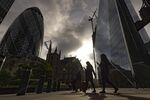 Commuters walk past skyscrapers in the City of London.