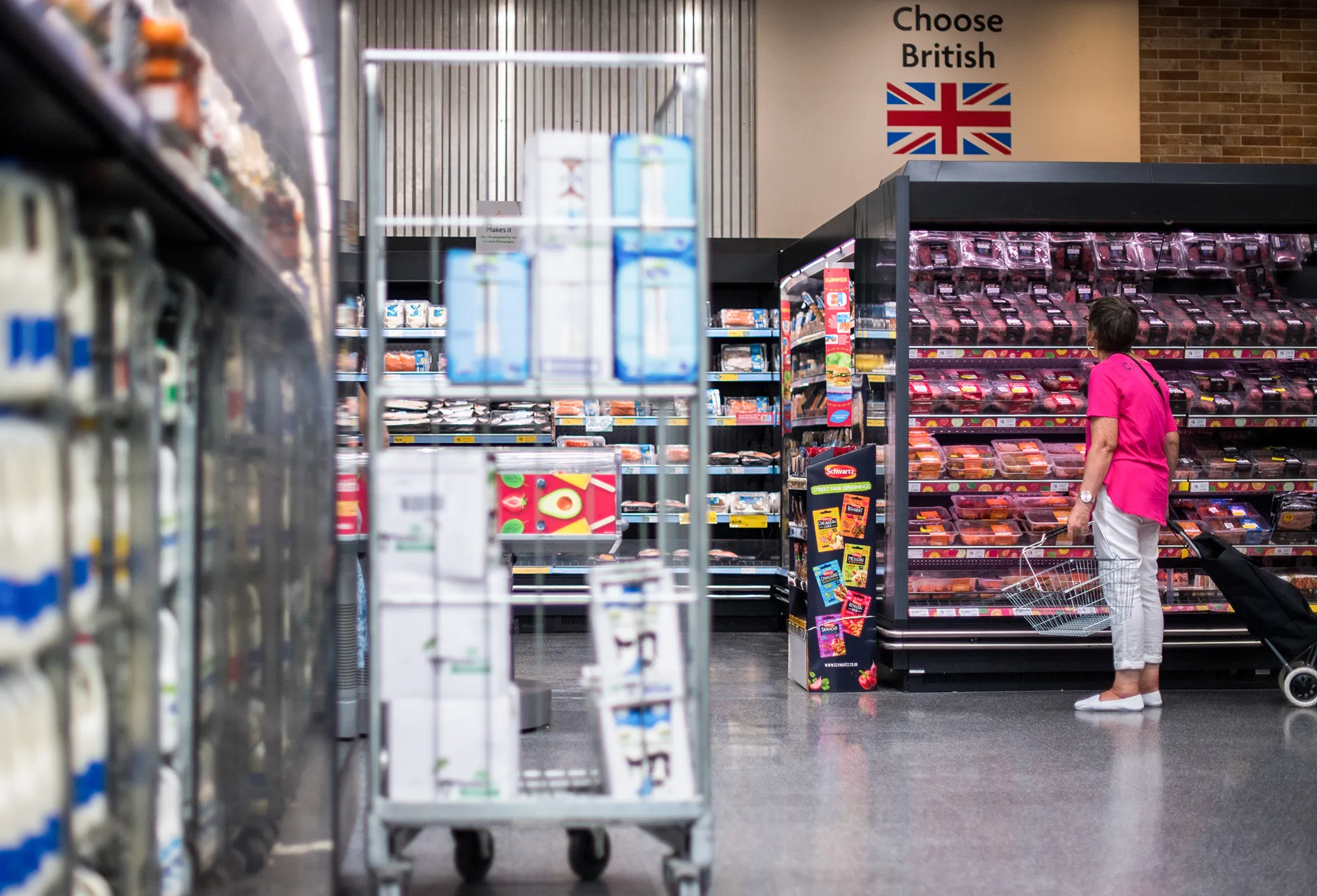 A customer browses meat under a sign encouraging customers to 'Choose British' inside a supermarket&nbsp;in London.