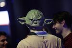 A Star Wars fan wears a Yoda mask.