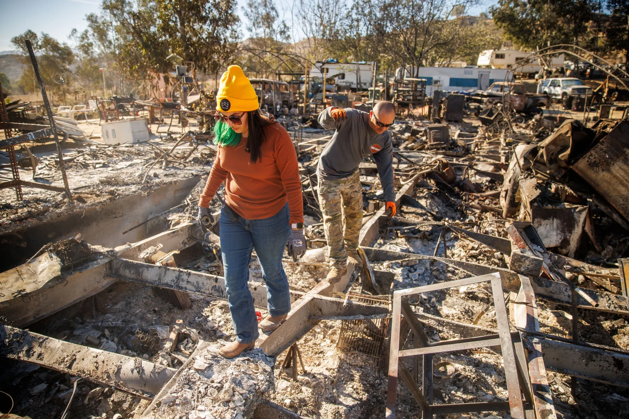 Relatives walk through the remains of their family's home after it was destroyed during the Highland Fire in Aguanga, California, US, on Tuesday, Oct. 31, 2023.&nbsp;