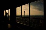 A visitor looks out towards the Telkom Tower and city skyline from the Ponte City Apartments building in the Berea district of Johannesburg, South Africa, on Thursday, Dec. 22, 2022. Johannesburg, South Africa’s economic hub and its richest city, is seeking electricity supply from private generators to reduce the amount of scheduled power outages. Photographer: Waldo Swiegers/Bloomberg