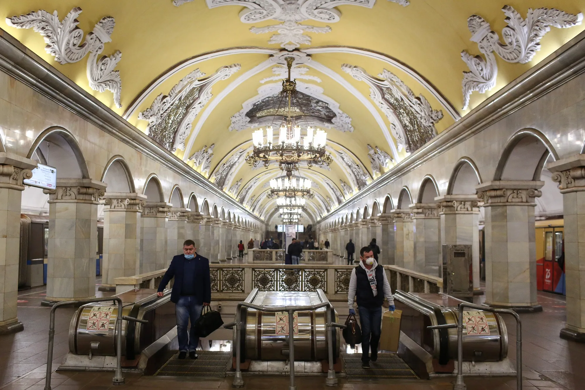 Passengers wearing protective face masks inside a Moscow Metro station.