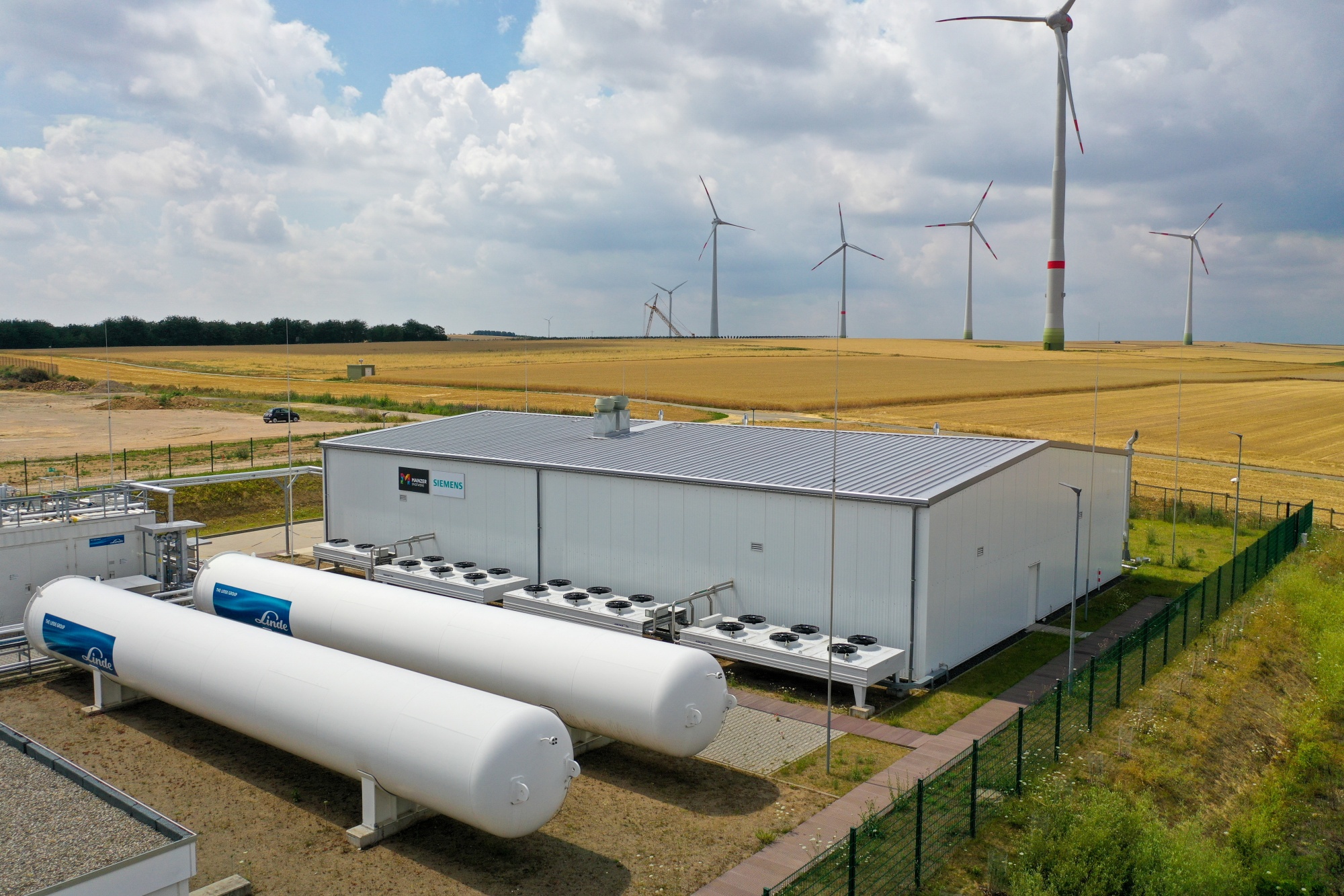 Wind turbines stand past a hydrogen electrolysis plant&nbsp;in Mainz, Germany.