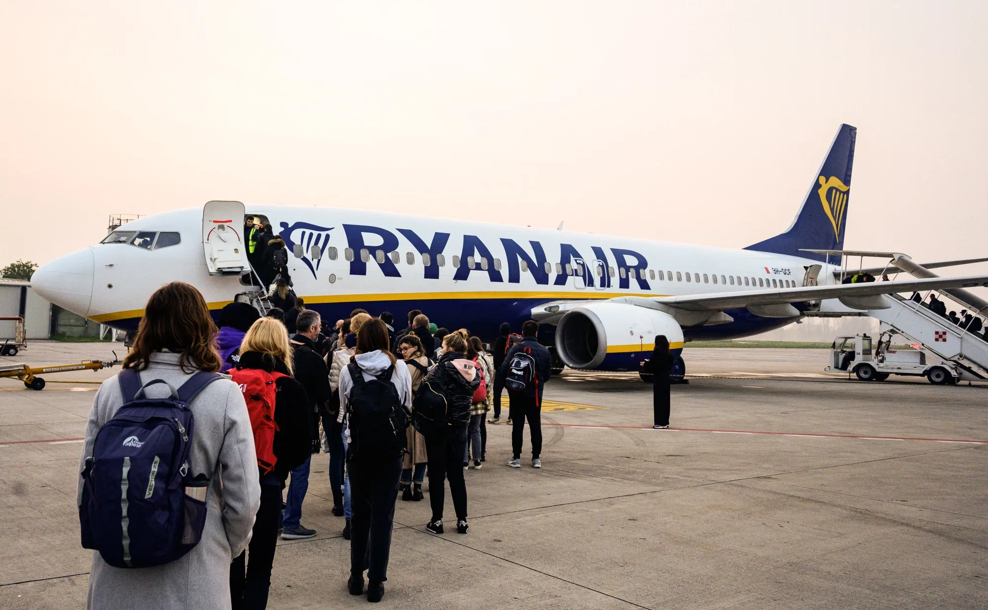 Passengers wait to board a Ryanair aircraft.