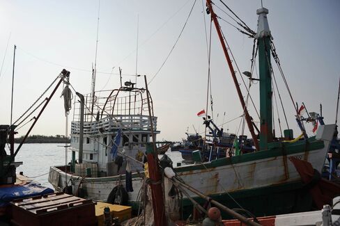 A wooden fishing boat used by a human trafficking syndicate to transport nearly 600 mostly Rohingya migrants from Myanmar and Bangladesh is seen anchored at Lhokseumawe fishing port located in Indonesia. Photographer: Chaideer Mahyuddin/AFP/Getty Images