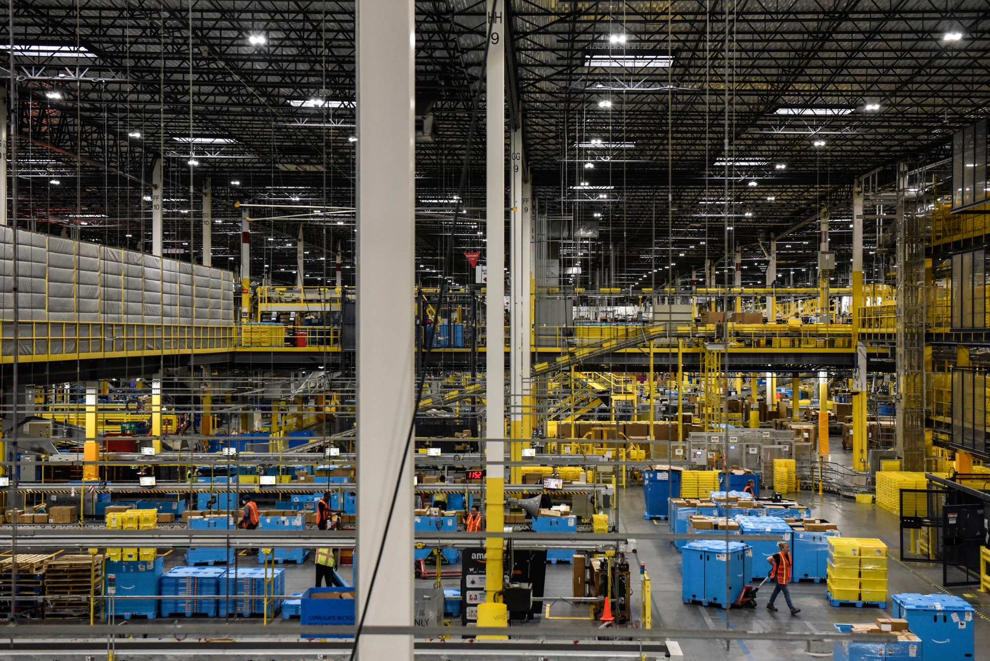 Employees prepare packages for shipping at an Amazon Fulfillment center.