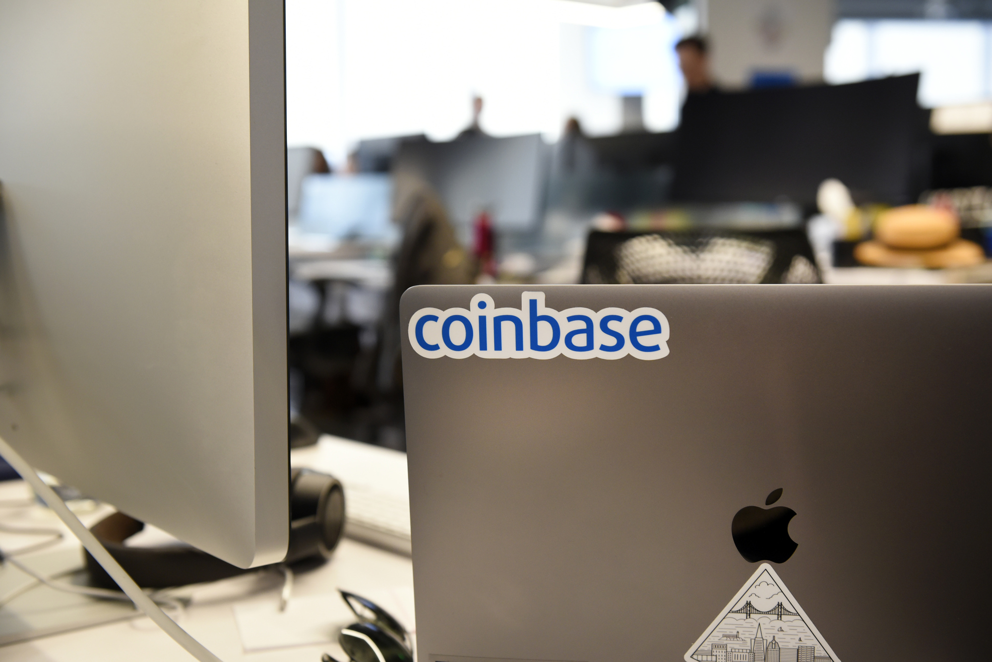 A Coinbase Inc. sticker is seen on a laptop computer at the company's office in San Francisco, California, U.S.