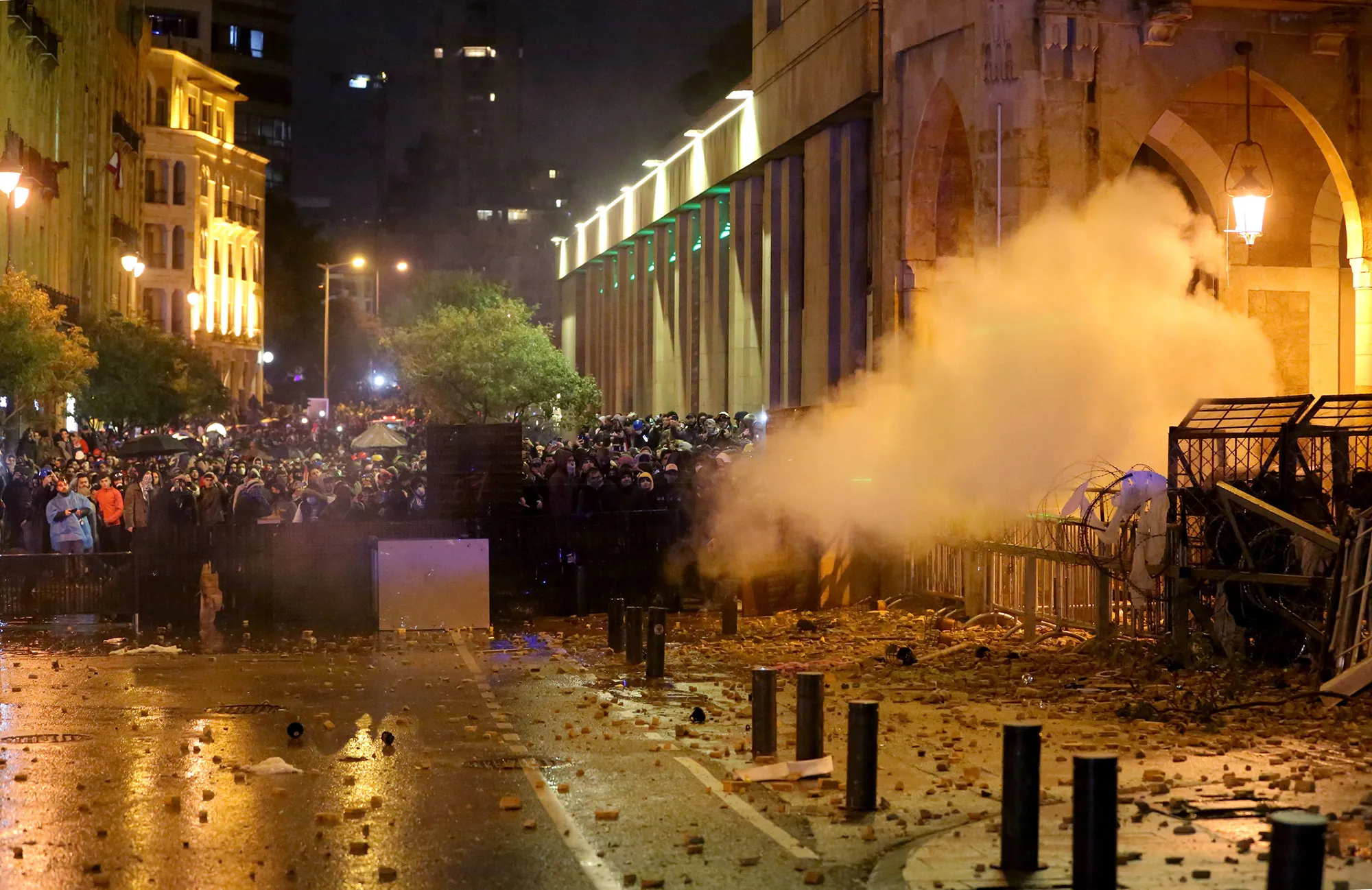 Lebanese protesters take cover behind a barricade amid clashes with riot police in&nbsp;Beirut on Jan,&nbsp;19.