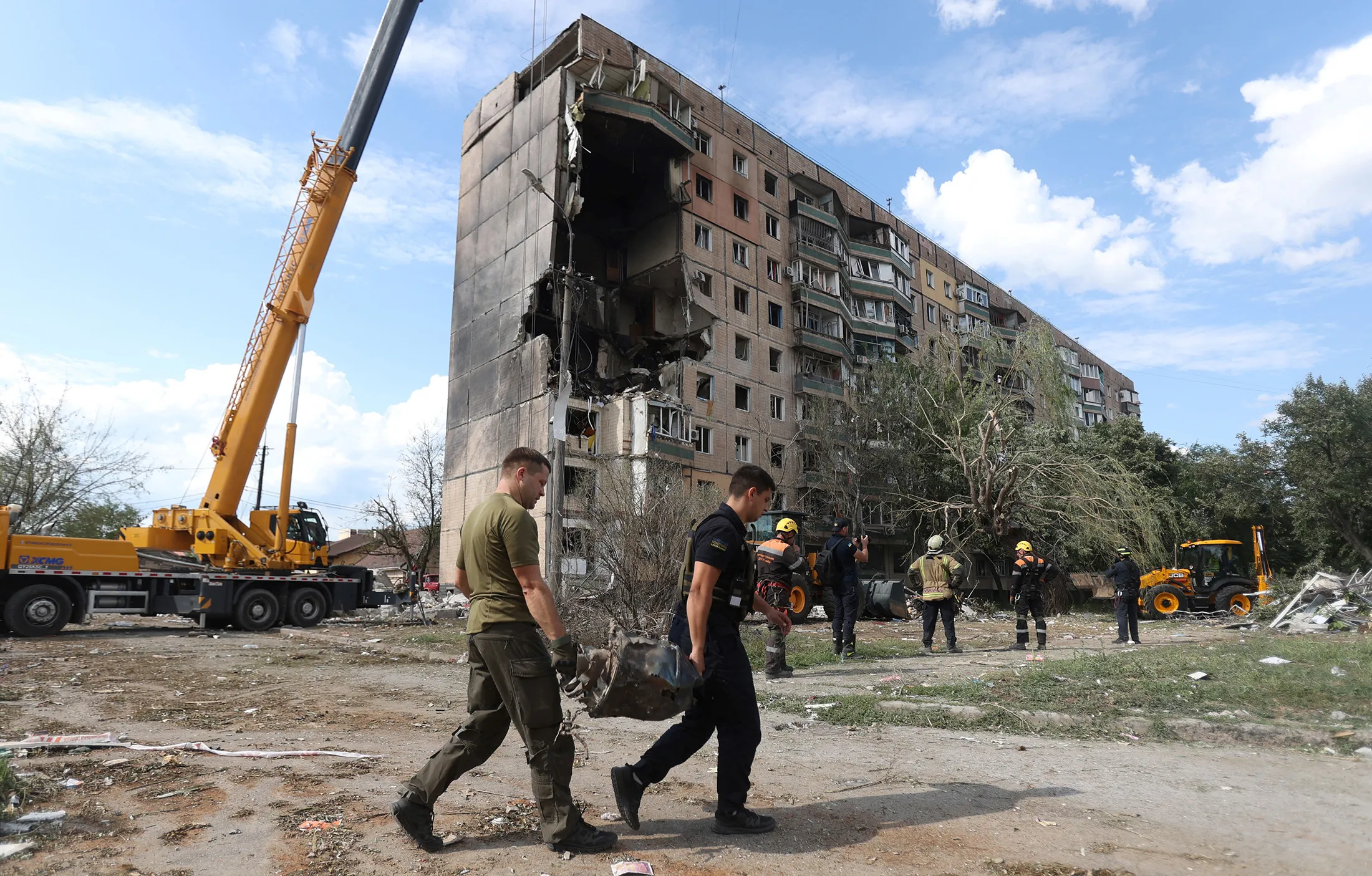 Rescuers carry a fragment of missile outside a&nbsp;residential building partially destroyed by&nbsp;Russian missile&nbsp;strikes in Kryvyi Rig on July 31.