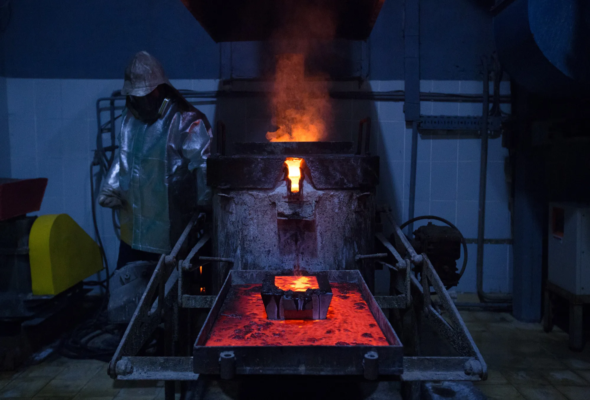 A casting mold filled with molten gold above a melting vat during the manufacture of gold ingots at a gold mine in Semey, Kazakhstan.