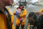 A rescue worker holds a crying baby rescued with her mother from a flooded home on Post Island Road in the Houghs Neck section of Quincy, Mass. during on March 2.&nbsp;