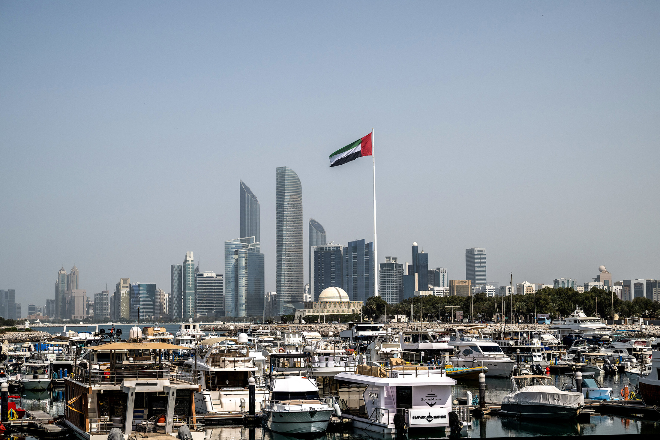 The United Arab Emirates flag and the Abu Dhabi Skyline following a reported Iranian strike on March 1, 2026. Photographer: Ryan Lim/AFP/Getty Images