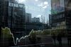 Buildings and pedestrians reflected on an electronic stock board outside a securities firm in the Shinjuku district of Tokyo, Japan, on Wednesday, Feb. 17, 2021. A surge in Japanese shares this week has pushed the Nikkei 225 past the 30,000 level for the first time since 1990.