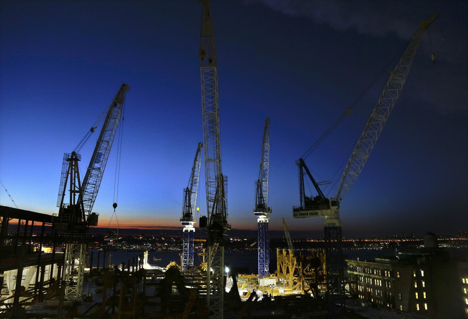 Cranes move loads of materials at dusk at the Hudson Yards construction site in New York. 