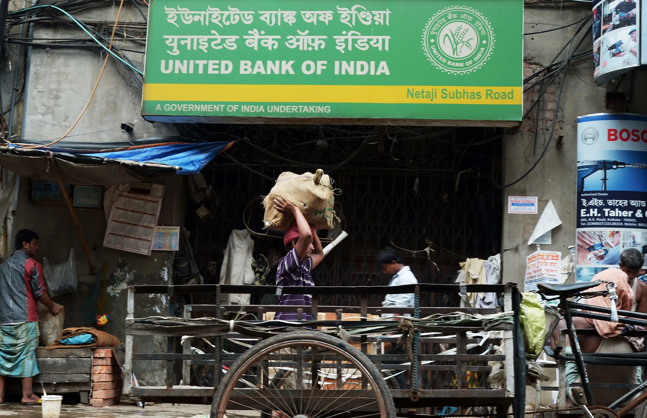 Indian labourers work in the street outside a bank in Kolkata, India, on August 22, 2014.
