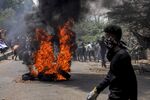 Anti-coup protesters walk past burning tires during clashes with security forces in Khartoum, Sudan, on June 30.