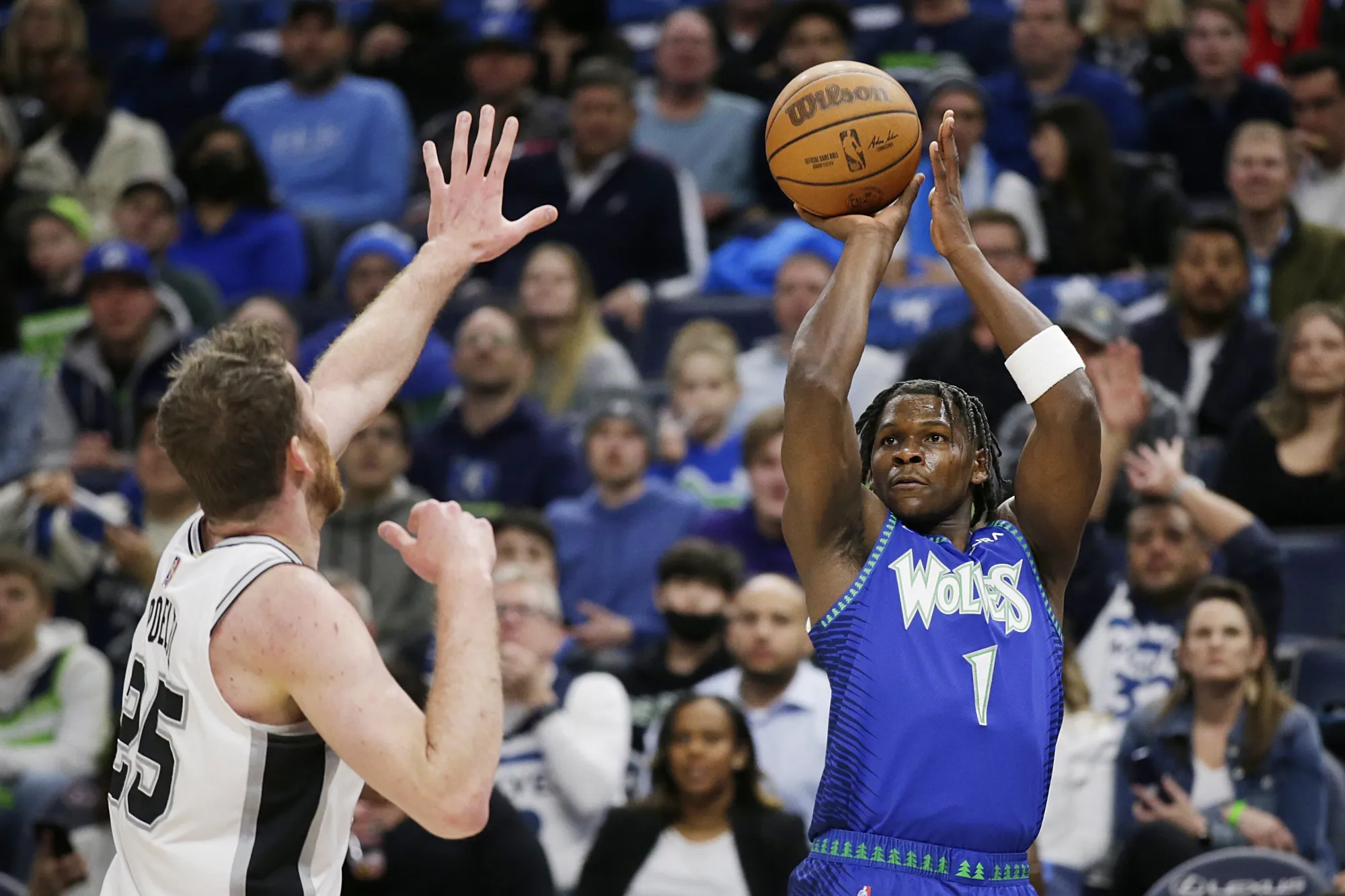 Minnesota Timberwolves forward Anthony Edwards (1) shoots on San Antonio Spurs center Jakob Poeltl (25) in the second quarter during an NBA basketball game Thursday, April 7, 2022, in Minneapolis.(AP Photo/Andy Clayton-King)
