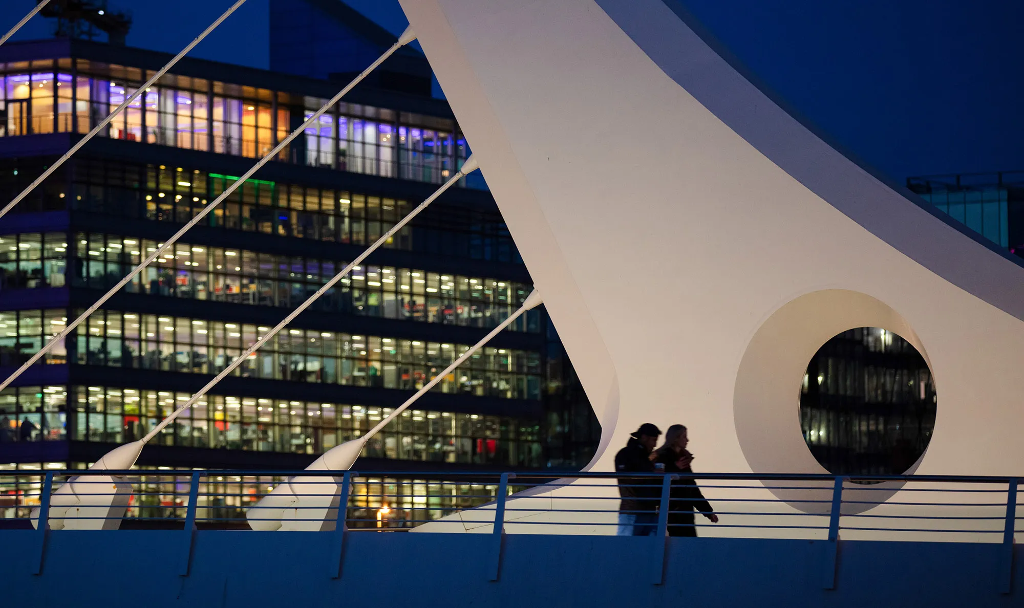 Pedestrians cross the Samuel Beckett Bridge in Dublin.