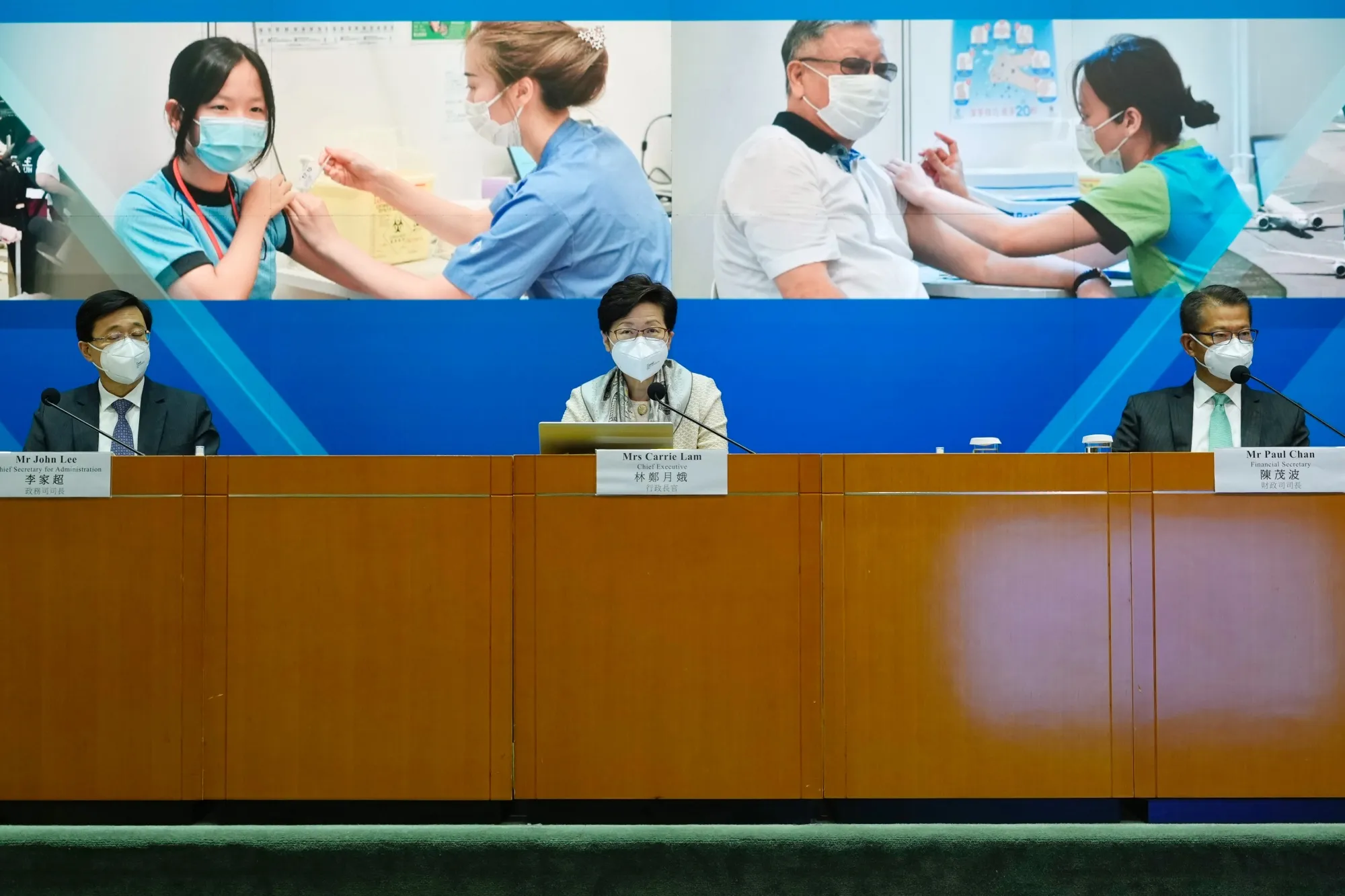 Carrie Lam, Hong Kong's chief executive, center, announcing&nbsp;changes to Hong Kong’s Covid rules.