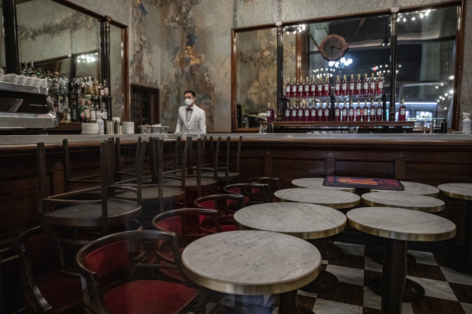 A worker prepares to closed a coffee bar before curfew in Milan, Italy, on Oct. 26.