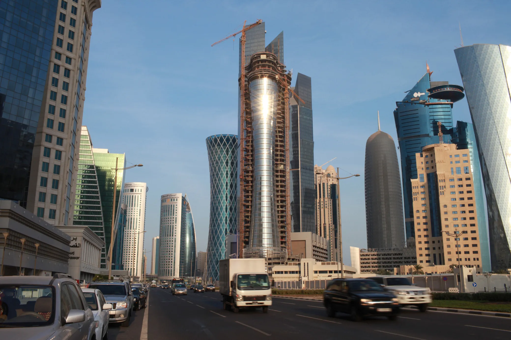 Traffic passes along a highway beside new high-rise buildings under construction in Doha, Qatar.